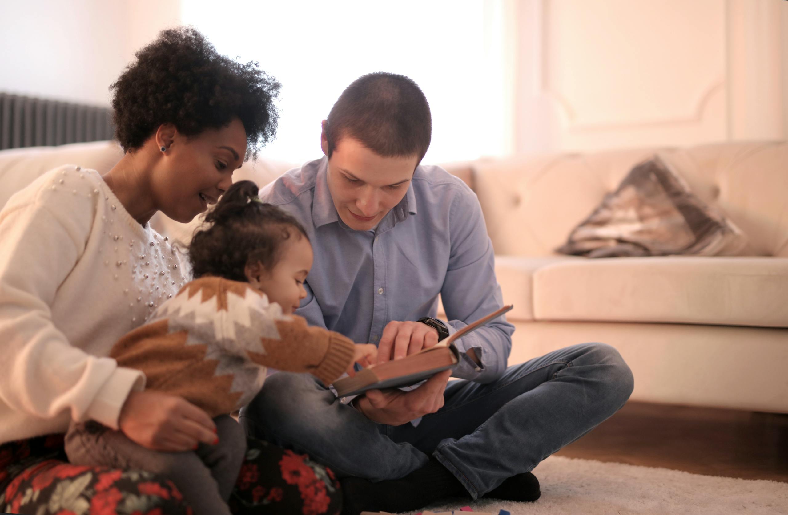 A diverse family enjoying storytime together, fostering love and learning indoors.