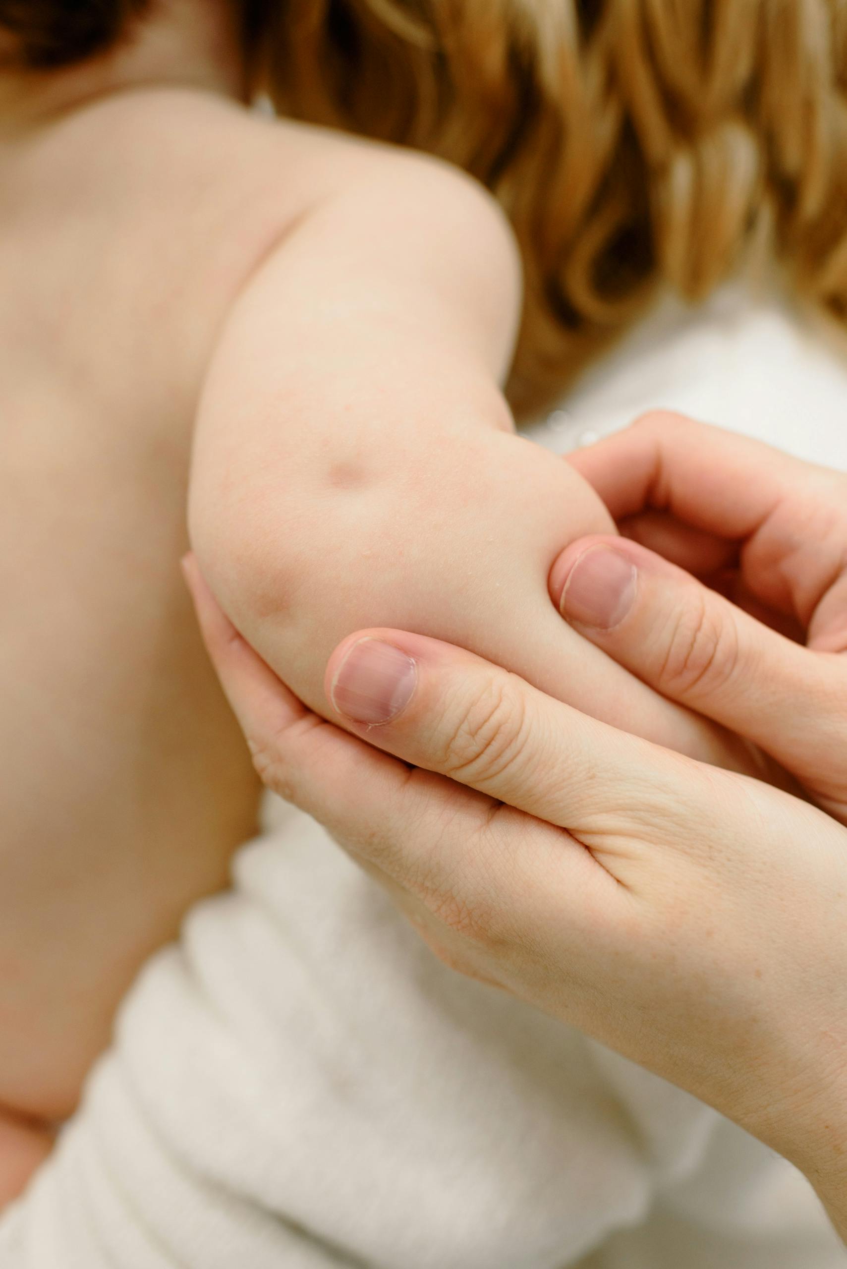 Close-up image of a baby receiving a gentle arm massage, highlighting the soothing touch.