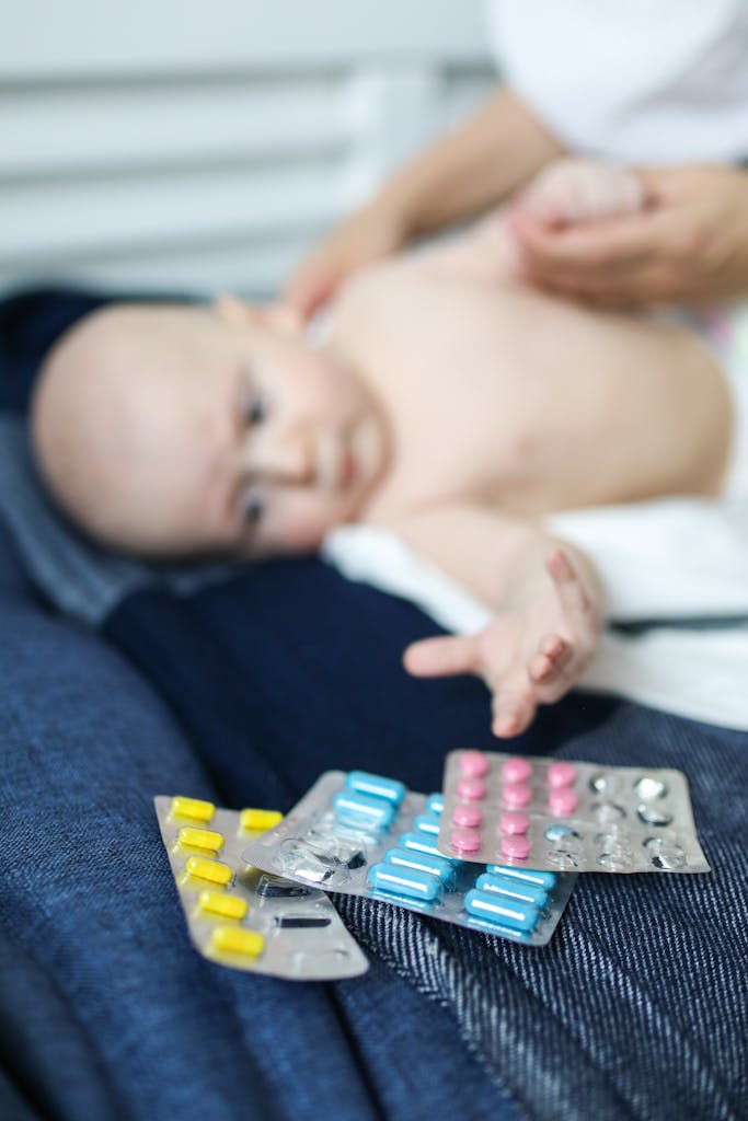A baby reaching towards blister packs of pills, emphasizing safety risks.